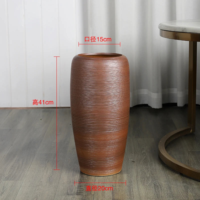 Un vase décoratif en céramique brun aux motifs ondulés, mesurant 41 cm de hauteur et 15 cm de diamètre.