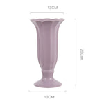 Élégant vase de table décoratif en céramique de couleur rose pâle avec une forme ondulée distinctive, mesurant 13 cm de hauteur et 13 cm de largeur.