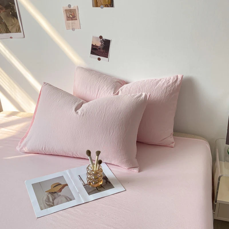 Un coin douillet avec des oreillers roses et des photos épinglées sur le mur, créant une ambiance chaleureuse et personnalisée.