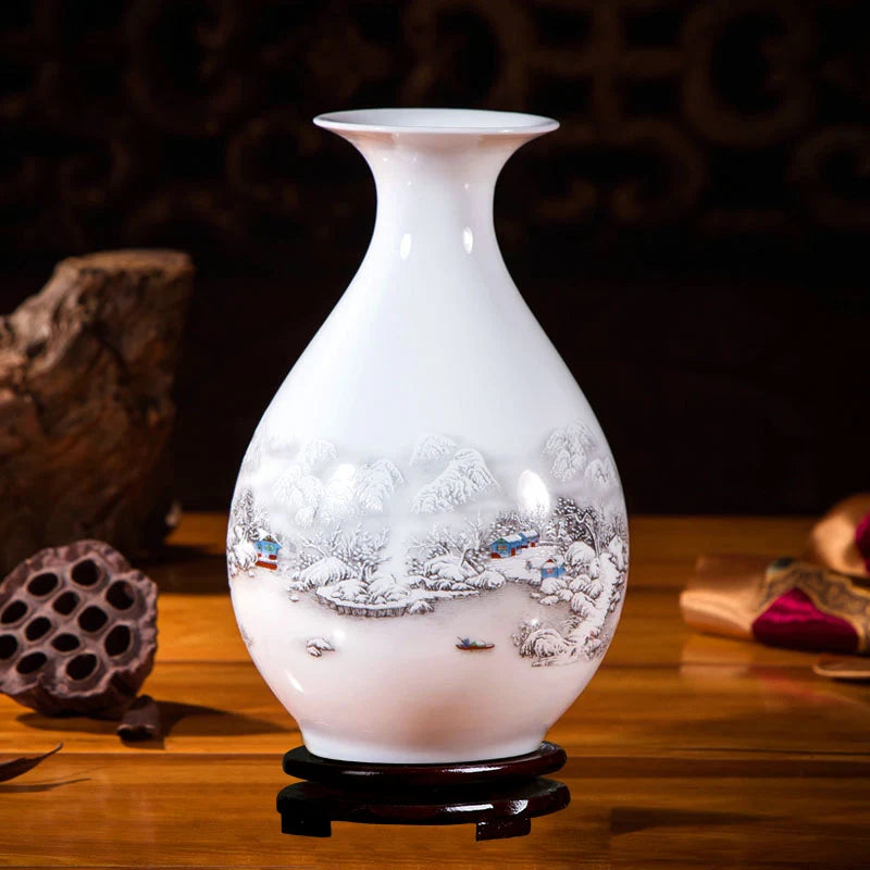 Vase en porcelaine blanche décoré d'un paysage hivernal avec des maisons et des montagnes enneigées.