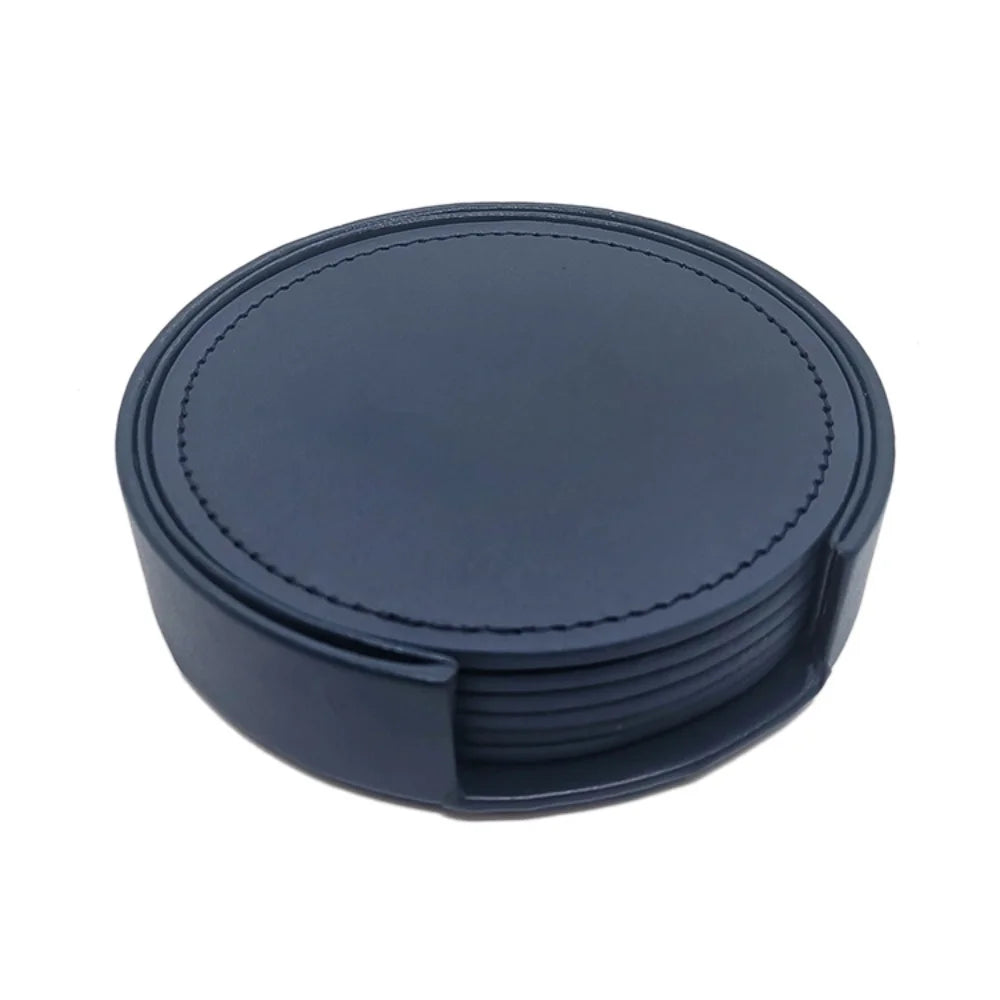 Sous-verres ronds en cuir noir empilés avec motif de couture, offrant une surface de protection élégante pour les tables.