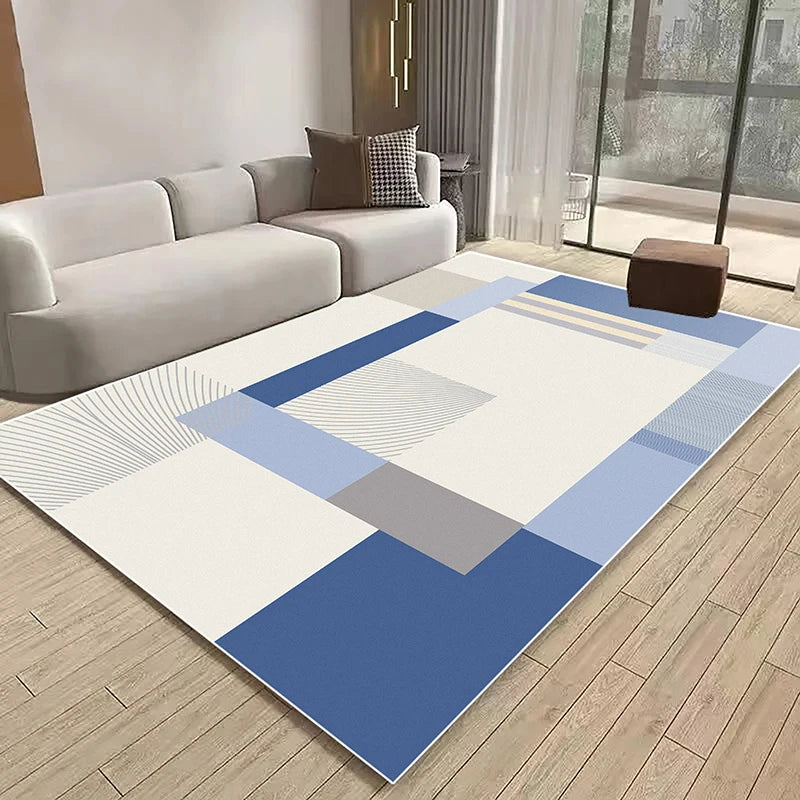 Tapis géométrique aux teintes bleues et grises posé dans un salon moderne avec un canapé blanc et un parquet en bois.