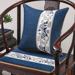 Coussin décoratif bleu et blanc sur une chaise ancienne en bois.