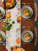 Cette image représente une table de fête automnale avec un repas succulent composé d'un poulet rôti, de soupes aux légumes, d'ustensiles de cuisine et de décorations d'automne telles que des citrouilles et des feuilles d'érable.