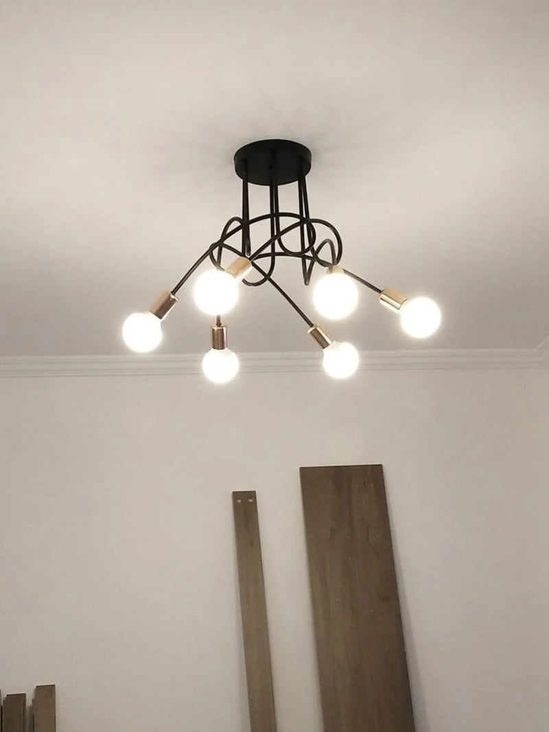 suspension lumineuse moderne noir doré ampoules blanches structure spirale fixation câbles métallique
