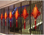 guirlande traditionnelle chinoise tissée artisanale rouge motifs géométriques pompon ruban doré festive printemps