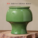 Vase de fleurs décoratif en céramique de couleur verte, avec des dimensions précisées.