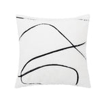 Coussin moelleux en blanc et noir avec des lignes incurvées abstraites.