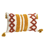 Coussin décoratif en coton blanc et jaune moutarde avec motifs graphiques et franges colorées.