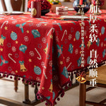 Une nappe de Noël rouge décorée de motifs colorés, de flocons de neige et de boules de Noël, créant une ambiance festive et chaleureuse pour les fêtes.