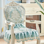 Chaise vintage ornementée aux motifs floraux délicats et touches de bleu pâle, confectionnée avec un soin et un style élégant, créant une atmosphère chaleureuse et raffinée dans l'espace.