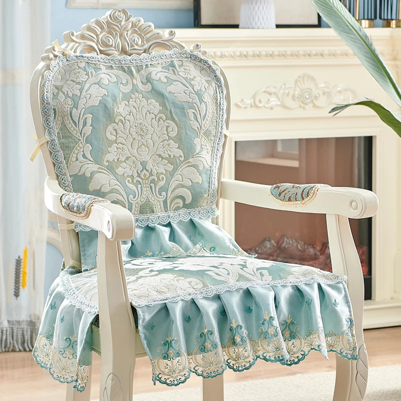 Chaise vintage ornementée aux motifs floraux délicats et touches de bleu pâle, confectionnée avec un soin et un style élégant, créant une atmosphère chaleureuse et raffinée dans l'espace.