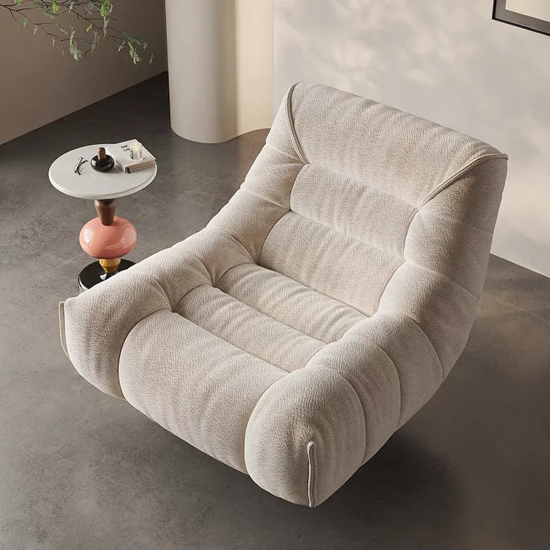 fauteuil pivotant moderne rose velours côtelé intérieur coussin décoratif livres vase fleurs