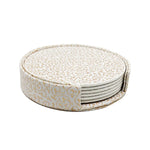 Dessous de plat ronds décoratifs en matériau blanc avec motif abstrait doré.