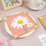 serviettes papier festives fleur blanche carreaux motif géométrique rose clair pliées dépliées jetables anniversaire
