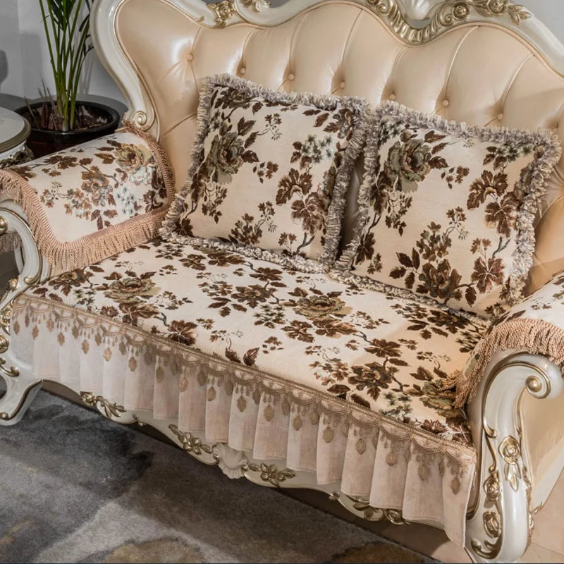 Un canapé vintage à capitons en cuir beige décoré de fleurs et de motifs dorés, créant une ambiance chaleureuse et élégante.