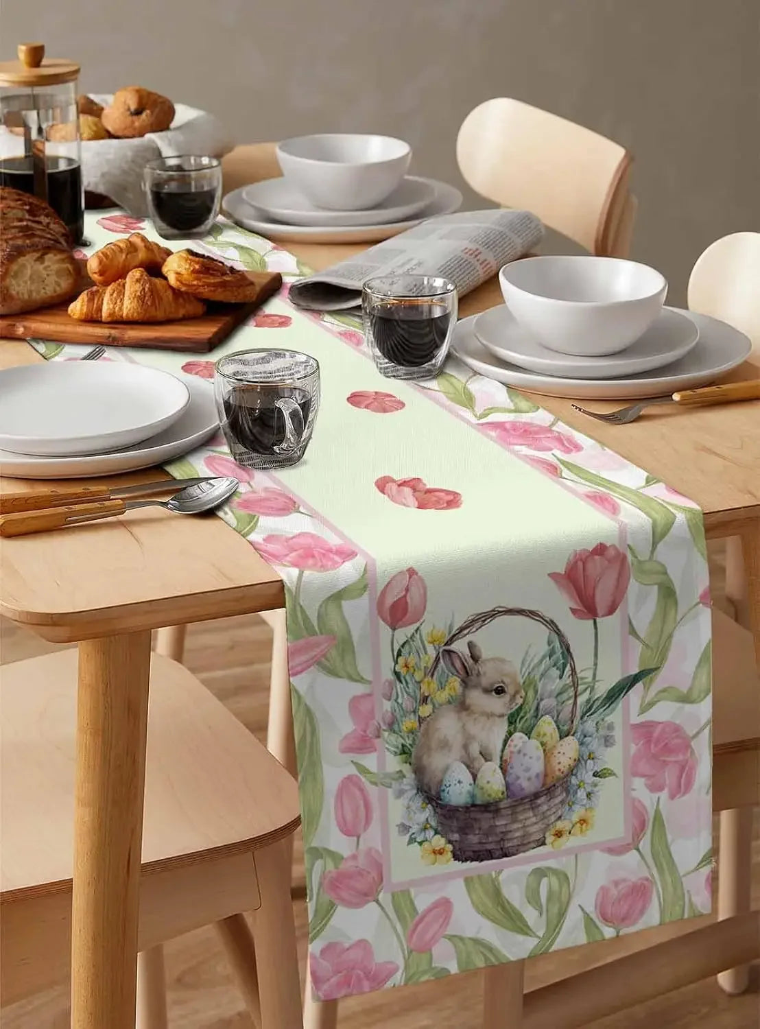 La nappe florale avec un lapin dans un panier pose une ambiance chaleureuse et printanière sur cette table dressée pour un petit-déjeuner.