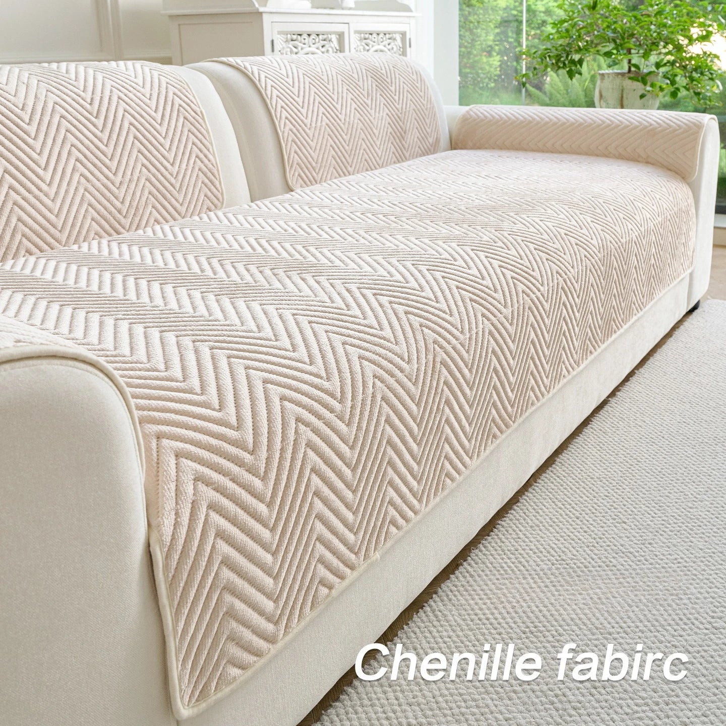 Le canapé en tissu chenille crème présente un motif chevronné élégant, offrant un style sophistiqué et une texture douce à cet espace de vie.