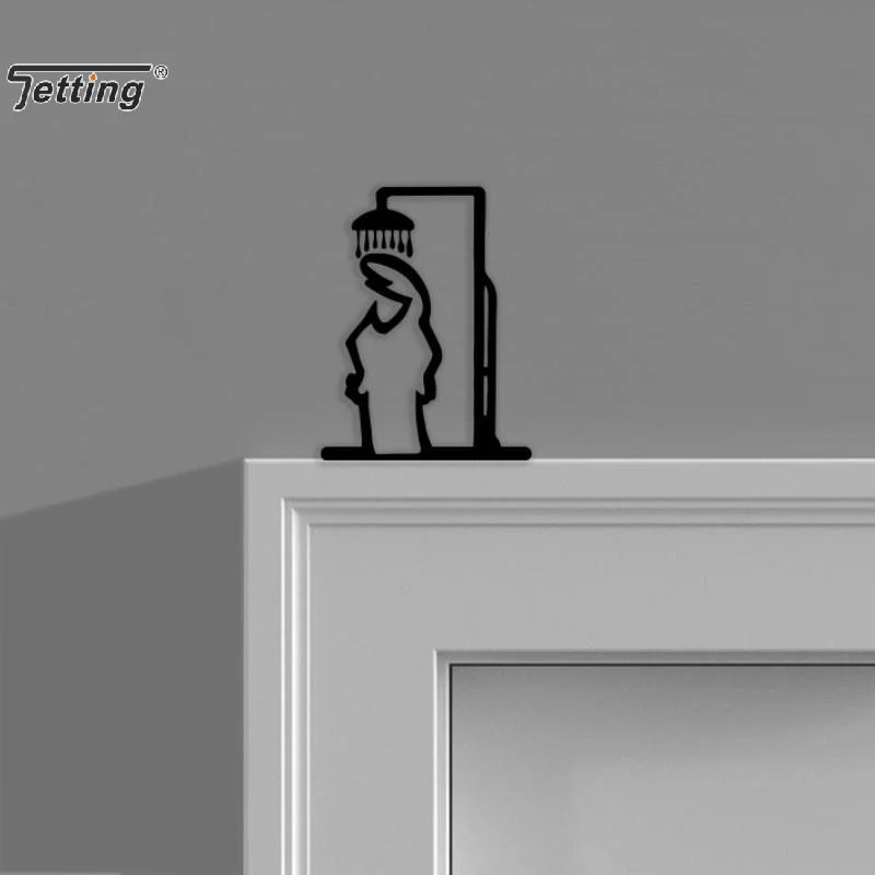 Figurine de douche noire accrochée sur un mur de salle de bains rustique