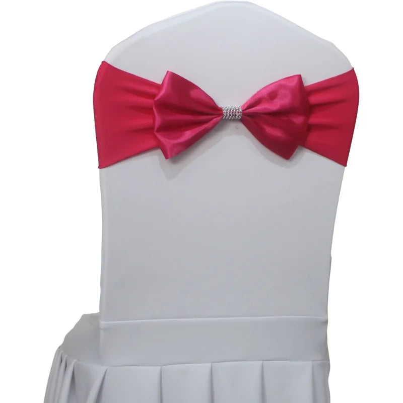 Nœud papillon satin rose foncé sur une chaise blanche, décoré d'un anneau métallique au centre.