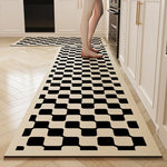 Tapis géométrique noir et blanc avec un motif de carreaux disposés de manière irrégulière sur un sol en bois clair.