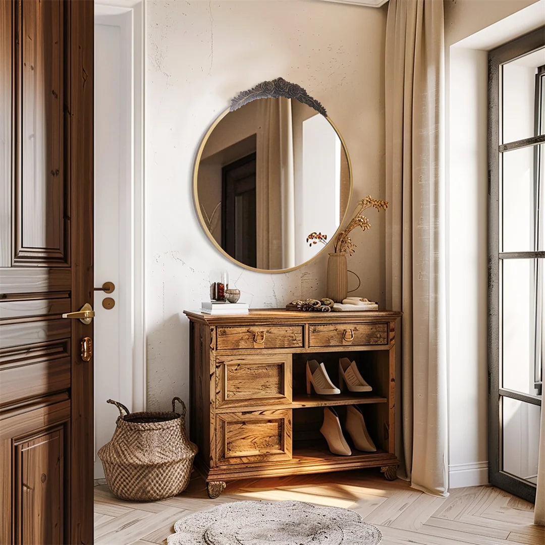 Un couloir spacieux avec un meuble en bois vintage abritant des chaussures, surmonté d'un miroir doré orné de motifs floraux, le tout complété par un panier en osier et un tapis décoratif au sol.