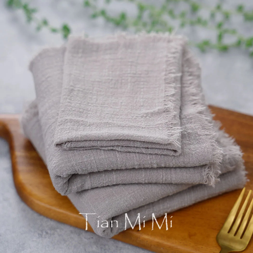 Serviettes de cuisine grises, empilées sur une assiette en bois, avec le nom de la marque "Lian Mi Mi" visible.