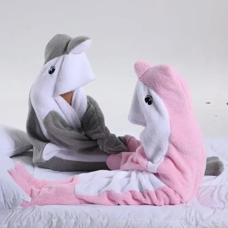 Un doux animal en peluche gris et rose posé sur un lit douillet.