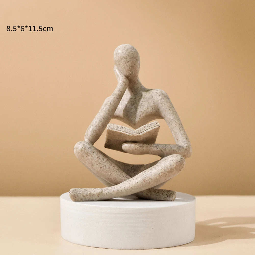 statue décorative résine figure humaine assise livre ouvert beige clair doré textures abstraites moderne