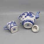 Théière et tasse en céramique décorées de motifs bleus et blancs représentant des dragons, offrant un style authentique asiatique.