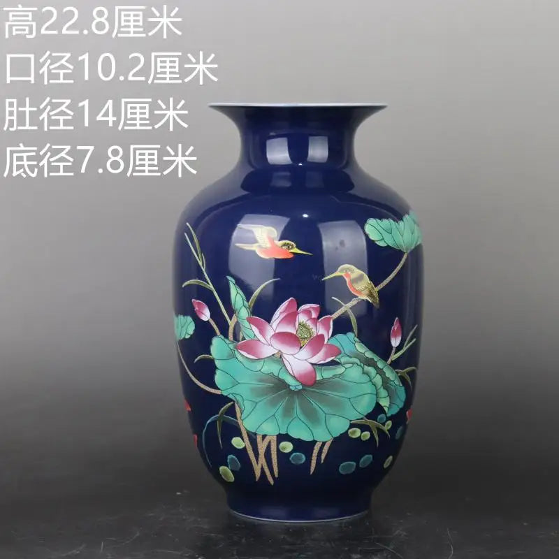 Vase en céramique décoré de fleurs de lotus et d'oiseaux colorés sur un fond bleu foncé, offrant une vision élégante et apaisante.