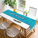 Une table de salle à manger avec des chaises blanches, une plante verte et un plateau de fruits sur le dessus, décorée d'un joyeux message sur un chemin de table.