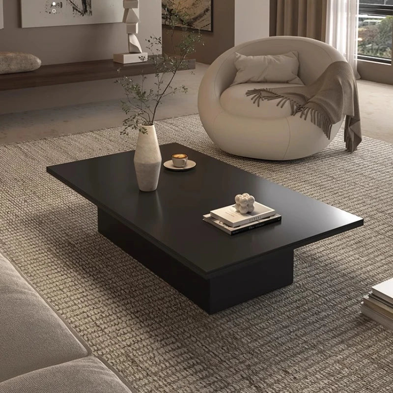 table basse moderne minimaliste noir blanche surface lisse tapis branches tasses livres coussins