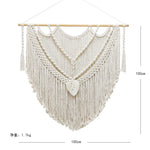 tapisserie macramé boho chic motifs géométriques franges beige clair tige bois crochets métalliques