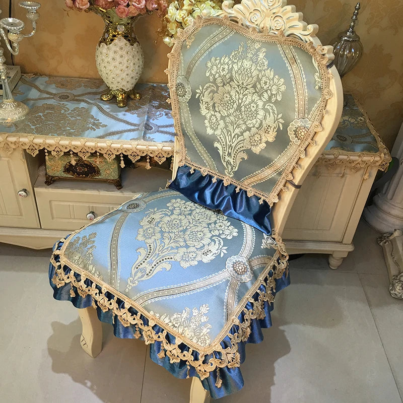 Chaise au design élégant avec broderies et dentelle, dans des tons de bleu et d'or, entourée de meubles vintage et d'accessoires décoratifs.