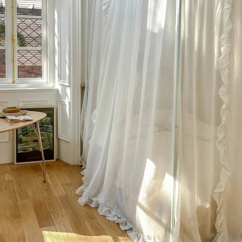 Intérieur lumineux avec rideaux blancs voilés, un décor minimaliste et épuré, créant une ambiance sereine et raffinée.