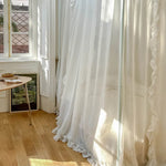 Intérieur lumineux avec rideaux blancs voilés, un décor minimaliste et épuré, créant une ambiance sereine et raffinée.