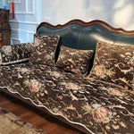 Un canapé en cuir vintage décoré de motifs floraux délicats, créant une atmosphère chaleureuse et élégante dans cette pièce.