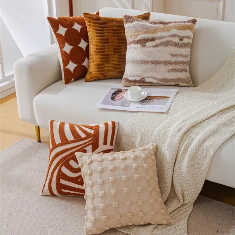 Un intérieur confortable et cosy avec des coussins décoratifs aux motifs colorés et textures variées, créant une ambiance chaleureuse et accueillante.