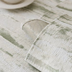 Gros plan sur un tissu de couleur grise et blanche texturé, avec des motifs abstraits et un aspect vintage.