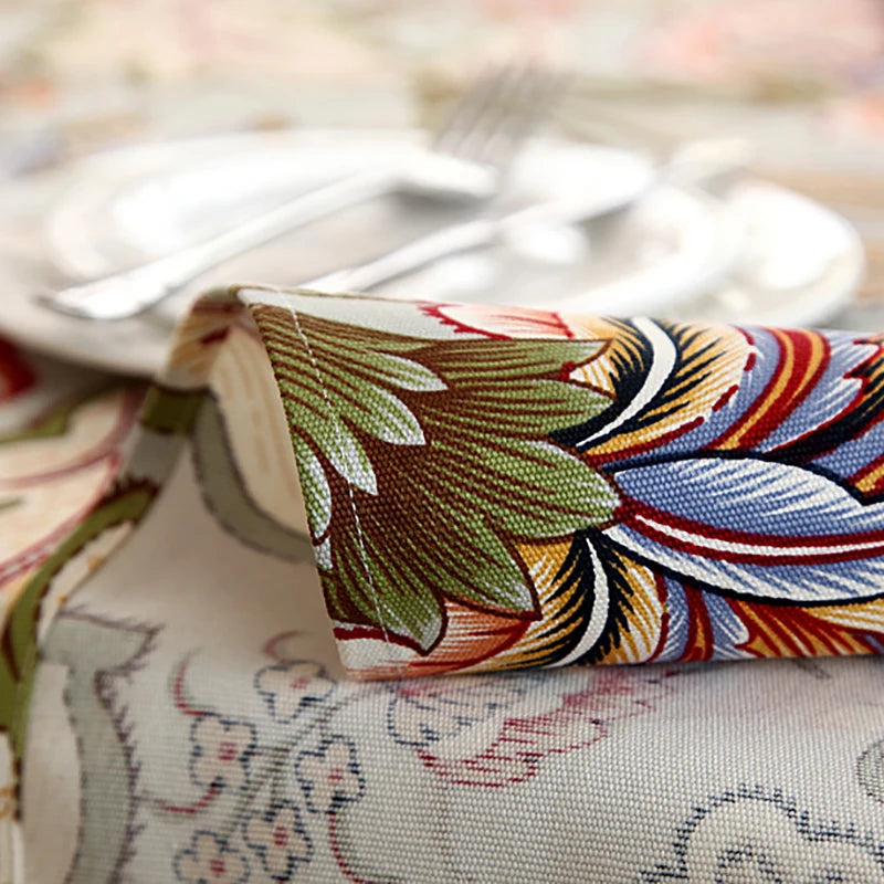 Un motif de plumes colorées, de lignes géométriques et de nuances chaudes ornent cette étoffes, créant une texture intéressante et décorative.