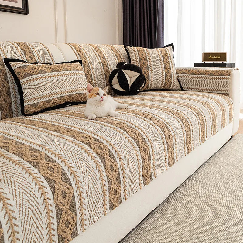 Un chat blanc assis sur un canapé avec un motif géométrique beige et brun