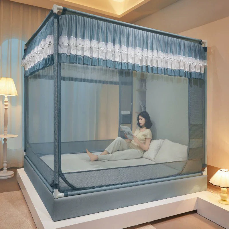 L'image montre un lit avec un cadre élégant en métal gris, décoré de rideaux bleus et blancs avec des ornements délicats. Une personne est assise sur le lit, en train de lire quelque chose sur un appareil portable.