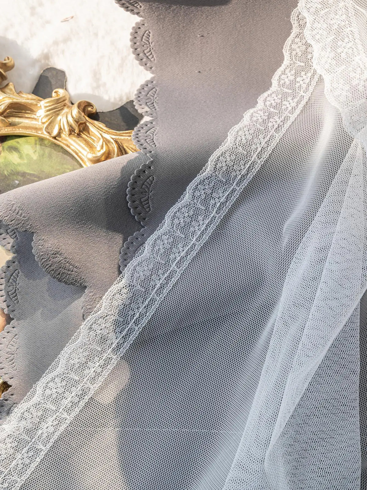 Détail du tissu du rideau gris montrant la texture et la double couche