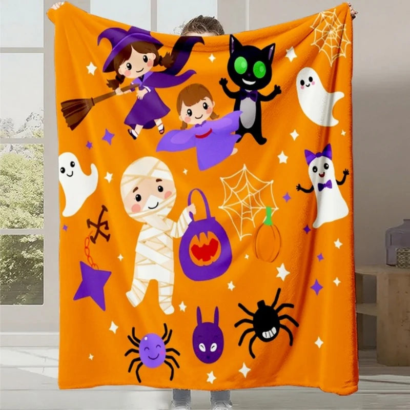 Une couverture en flanelle orange vif ornée de silhouettes amusantes de sorcières, de fantômes, de citrouilles et d'autres éléments décoratifs d'Halloween.
