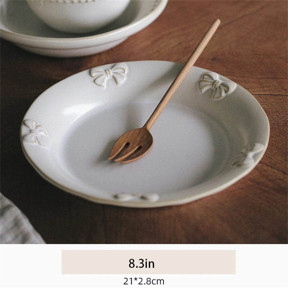 Assiette blanche ornée de motifs floraux avec un ustensile en bois posé dessus, sur une surface en bois foncé.