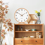 horloge moderne bois naturel cadran blanc chiffres noirs fond violet gris