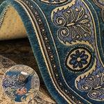 Riche tapisserie bleue et dorée ornée de motifs géométriques complexes et élégants.