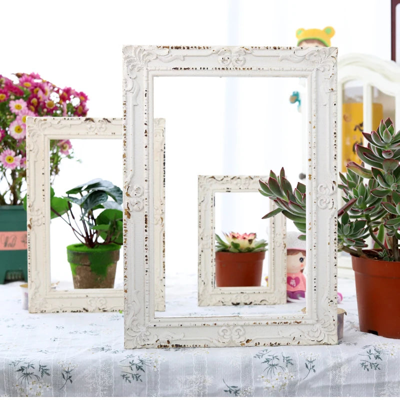Cadre photo en bois blanc vintage avec motifs floraux en relief vu de face