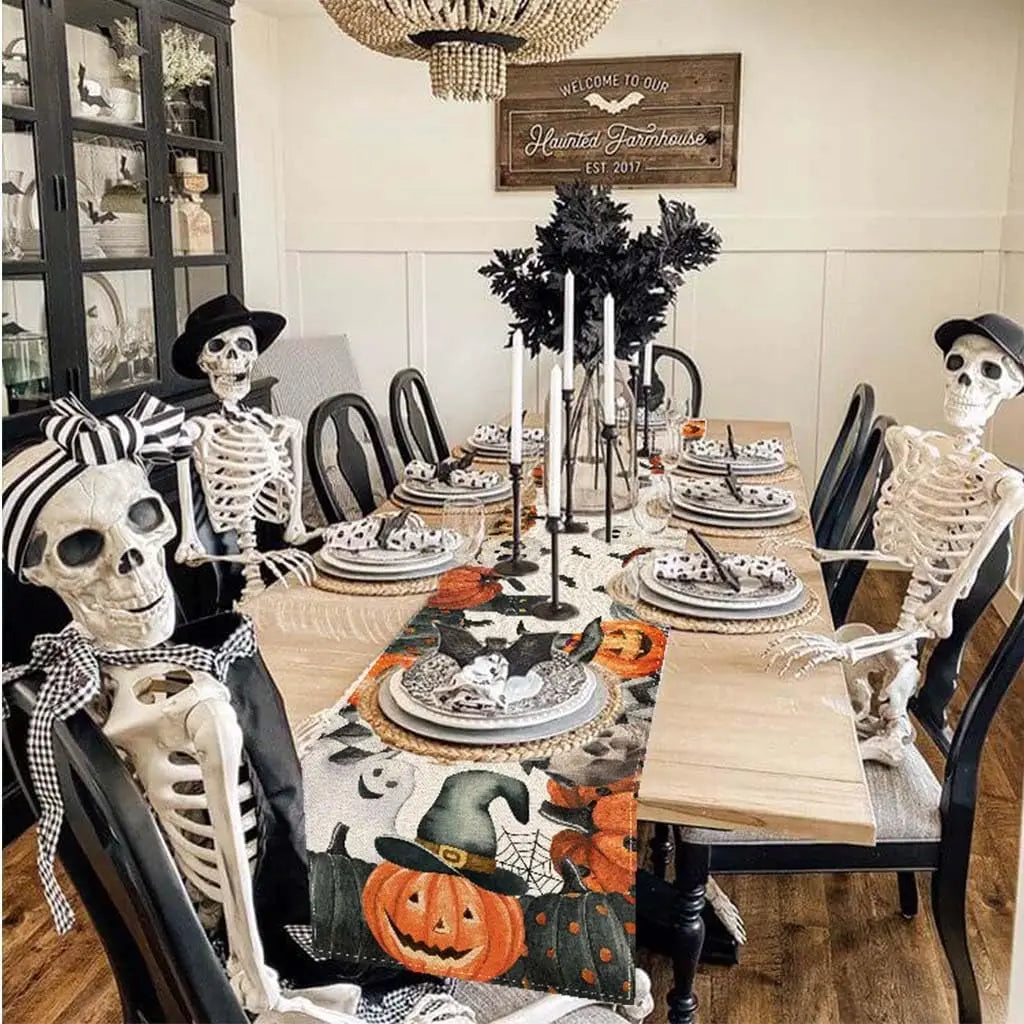 L'image montre une table de salle à manger décorée pour l'Halloween, avec des squelettes, des citrouilles et des décorations noires et blanches, créant une ambiance fantomatique et festive dans cette maison hantée.